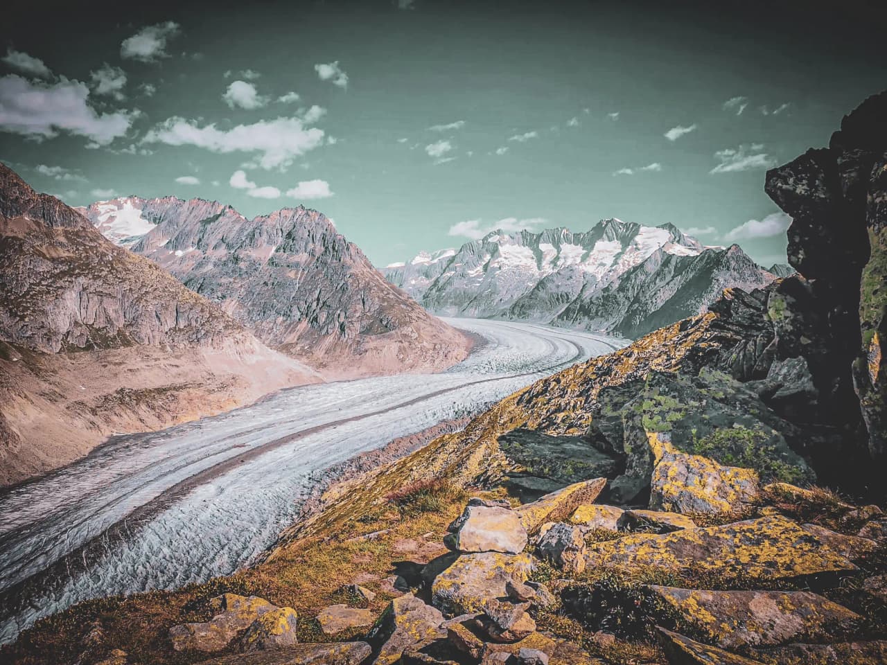 Spectacular views of the Aletsch glacier, surrounded by majestic peaks and blue skies.