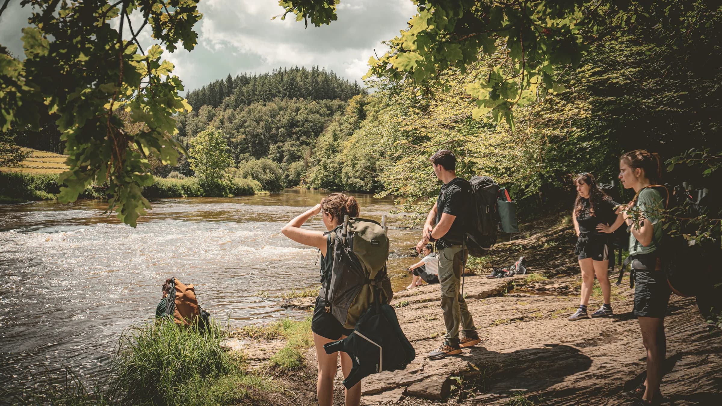 Een groep avonturiers aan de oevers van de Semois, klaar voor een tocht per backpack in het hart van de natuur.
