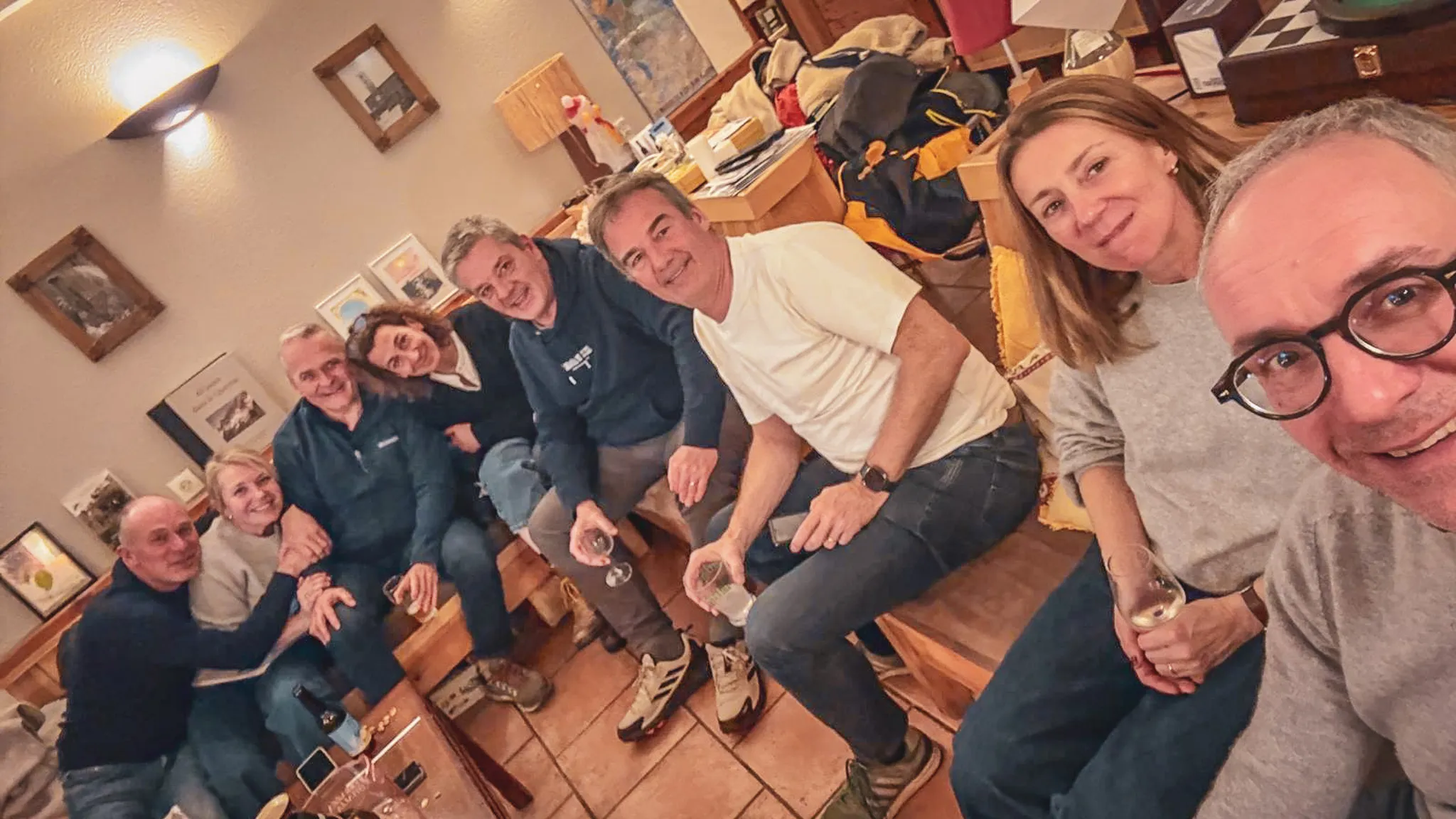 Groupe d'amis riant autour d'un verre, après une journée d'aventure en ski dans le Queyras.