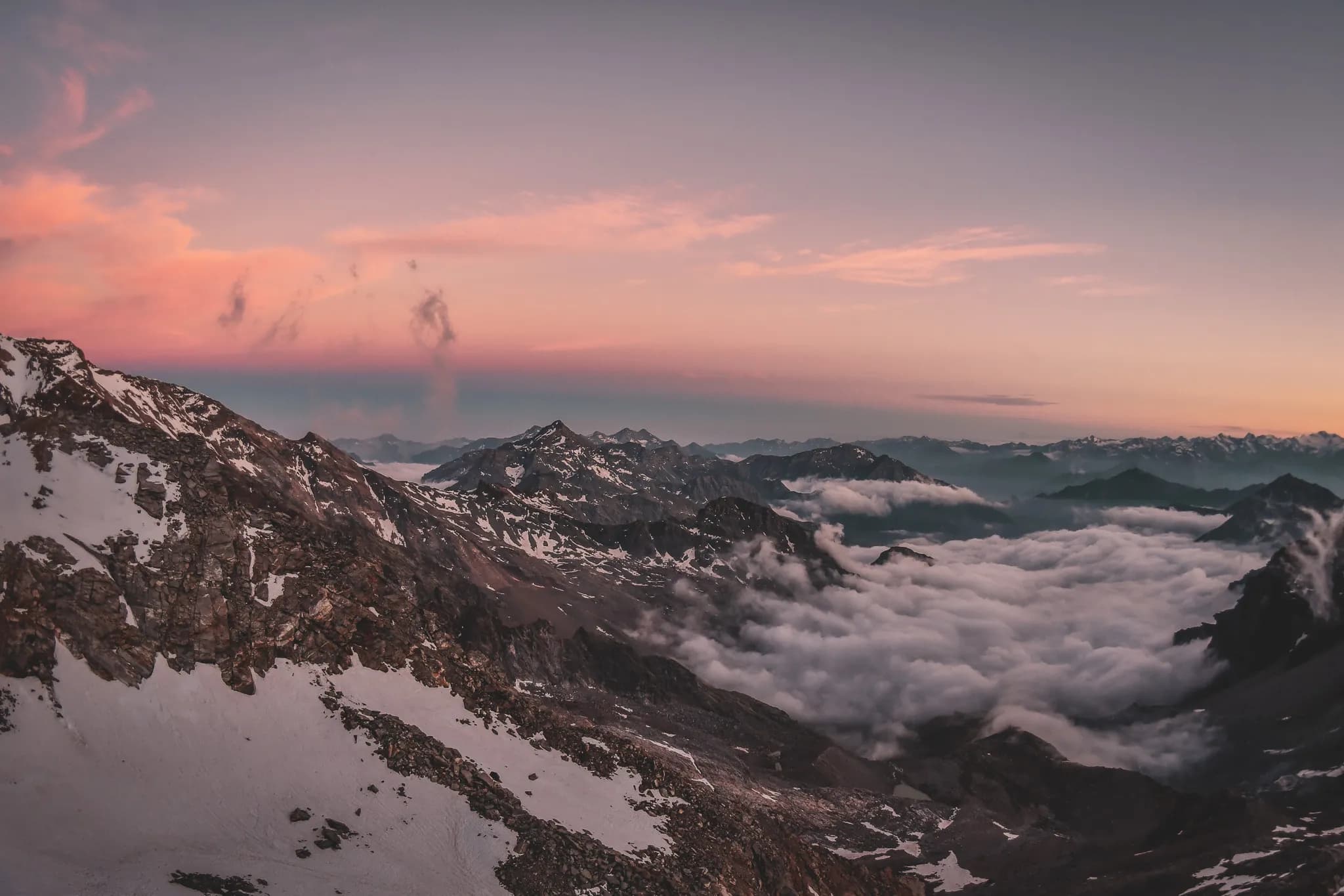 Spectacular panorama of the Alps with clouds and majestic peaks at sunset.