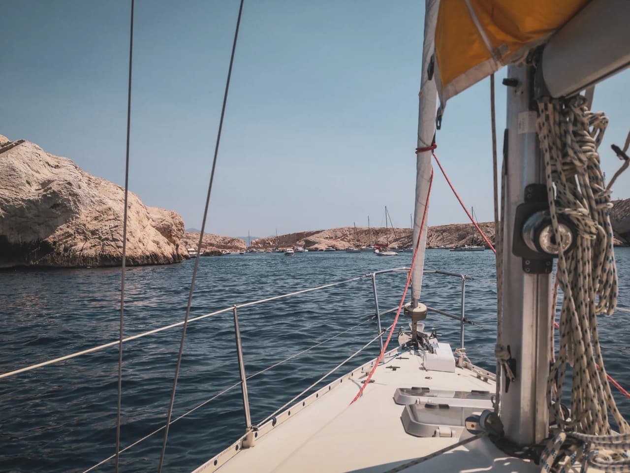Navigation paisible en voilier dans les eaux turquoise des Calanques, entouré de falaises.