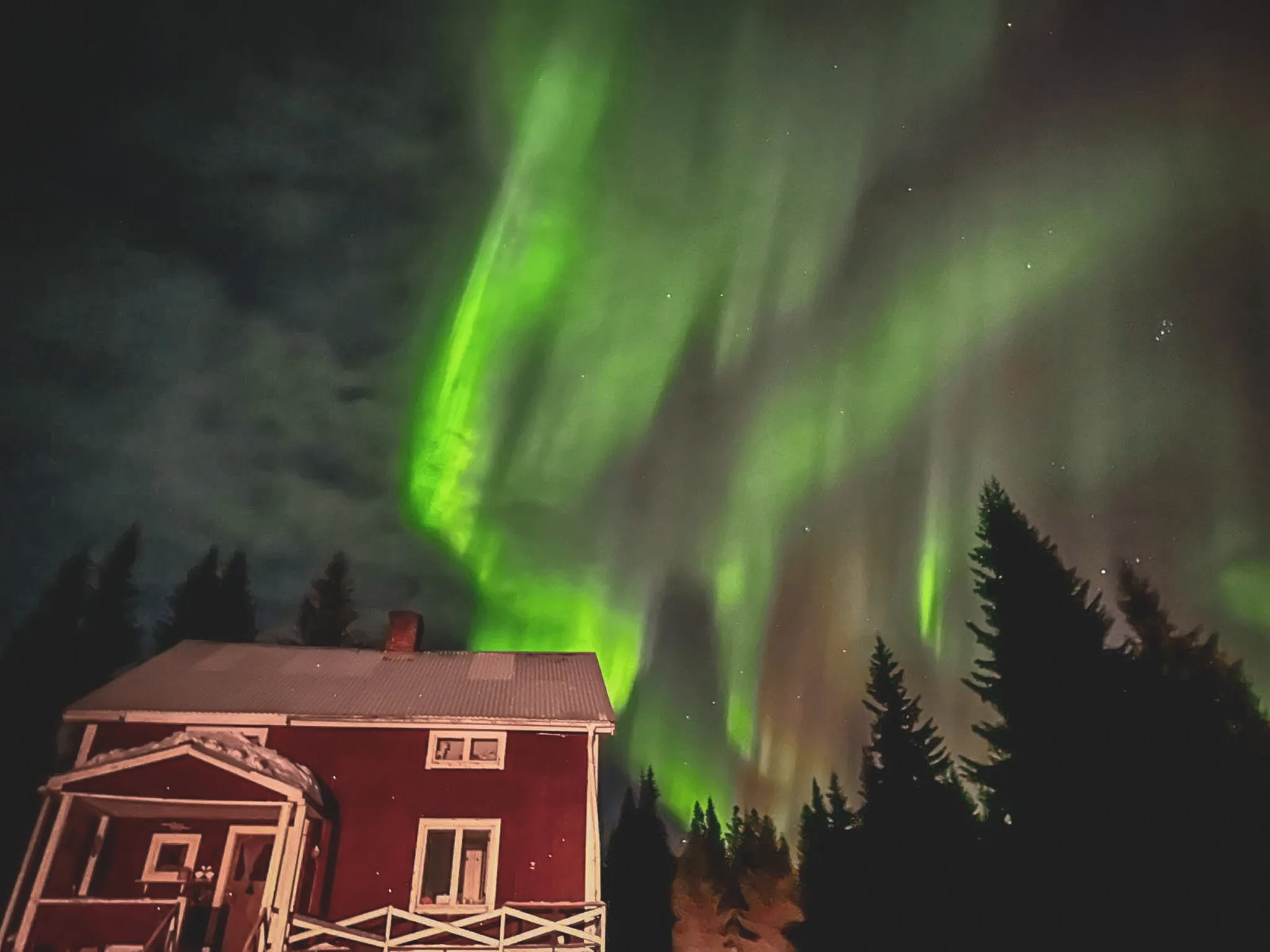 Warme houten kamer met knus bed, ideaal om te ontspannen na avonturen in Lapland.