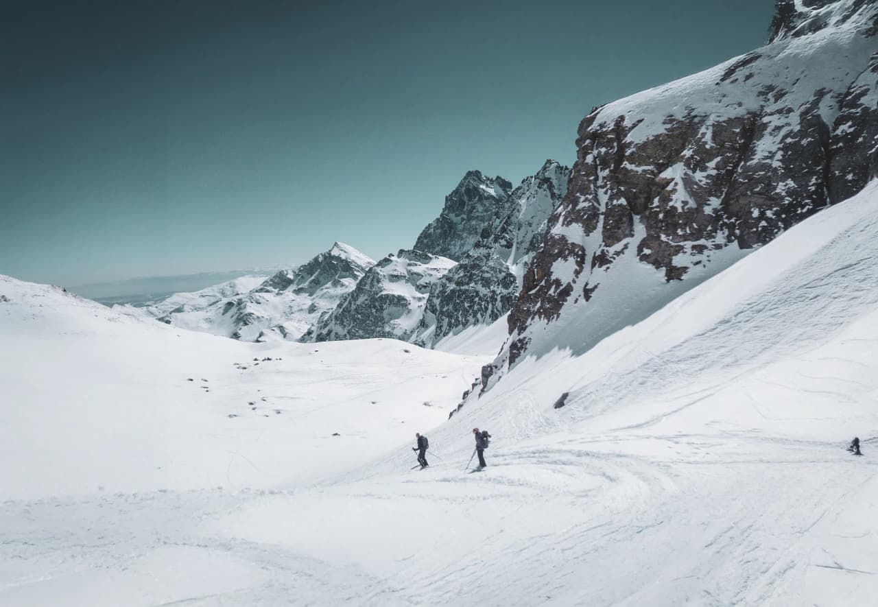 Deux skieurs de randonnée explorent la neige immaculée du Mont Viso, au cœur des Alpes.