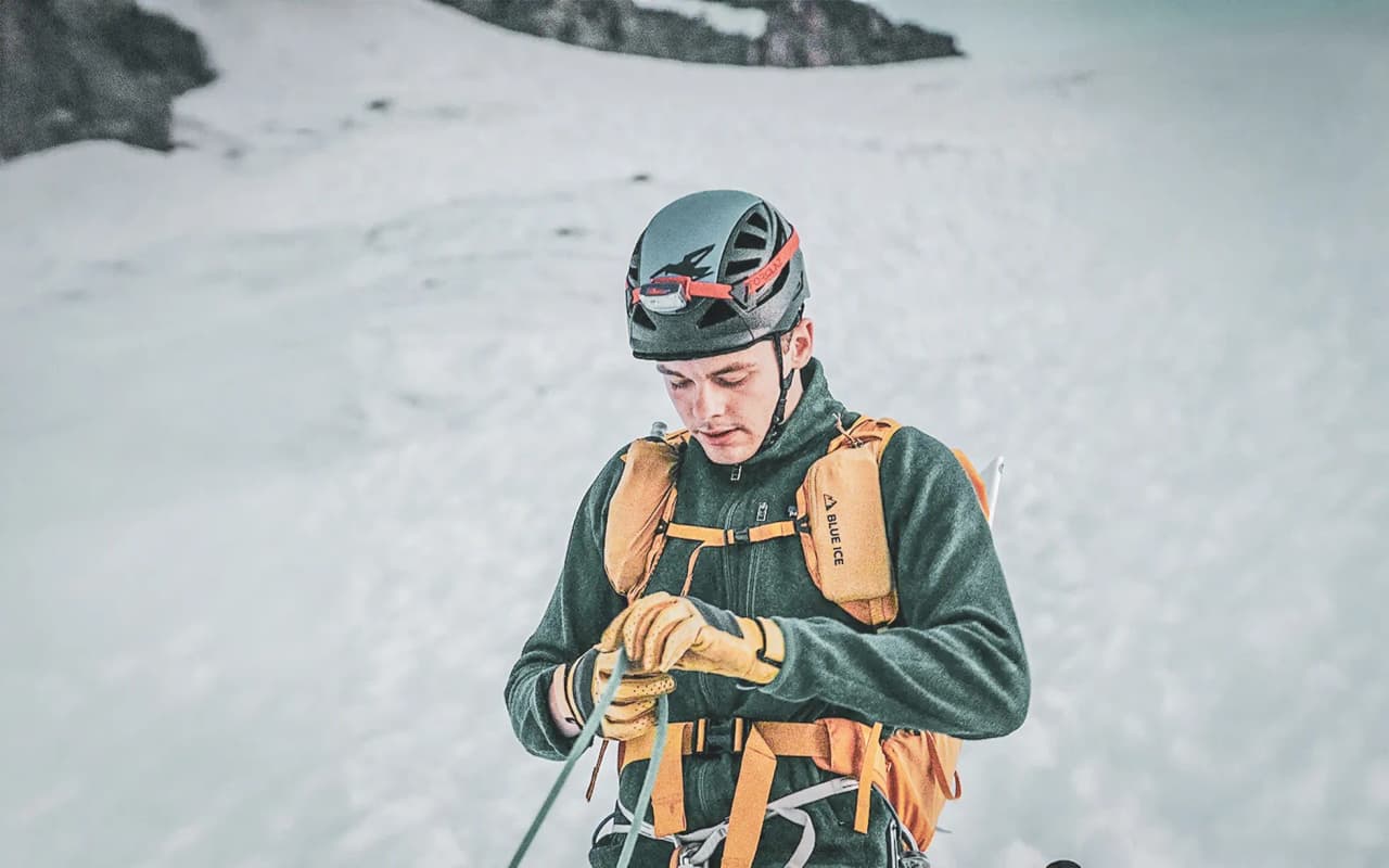 Montagnard concentré, préparant son matériel sur un glacier, prêt pour l'aventure à Chamonix.