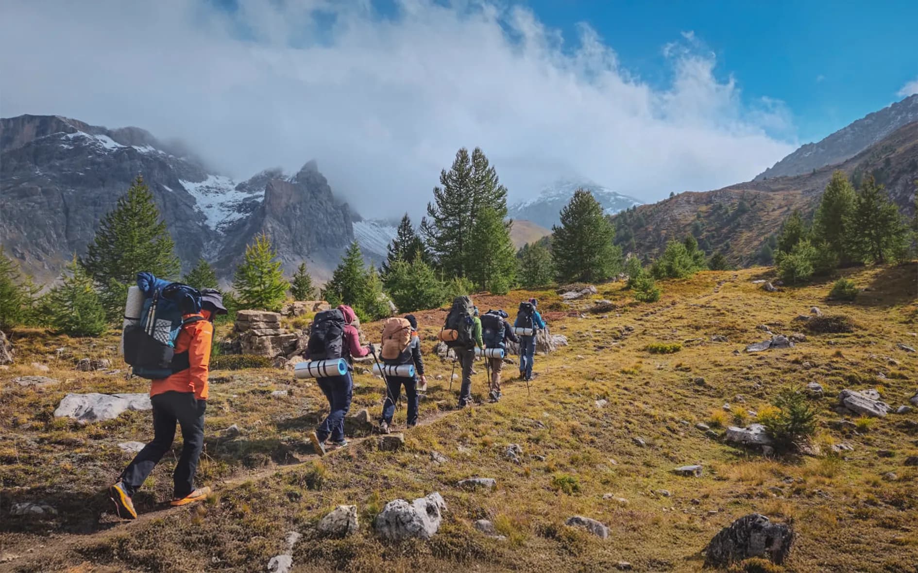 A group of adventurers trekking through the magnificent Ubaye countryside, mountains and blue skies.