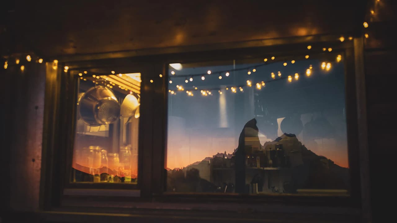 Reflection of a mountain at sunset in a window decorated with garlands.