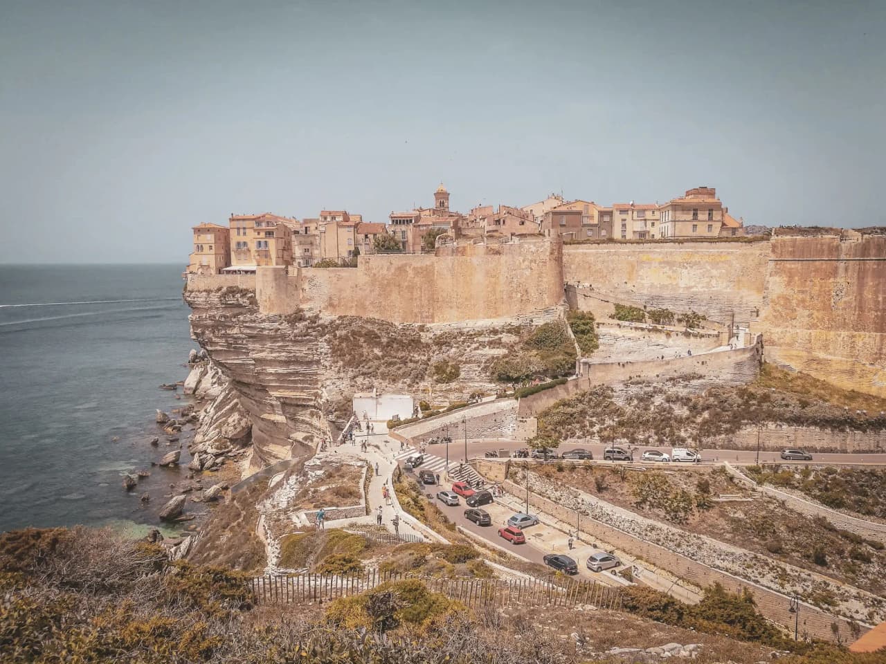 Vue panoramique de Bonifacio, bastion de calcaire surplombant la mer turquoise, invitation au voyage.