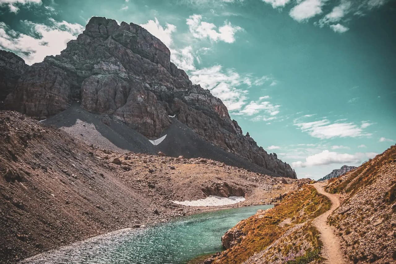 Majestic Alpine scenery with turquoise lakes, rocky slopes and blue skies, an invitation to adventure.