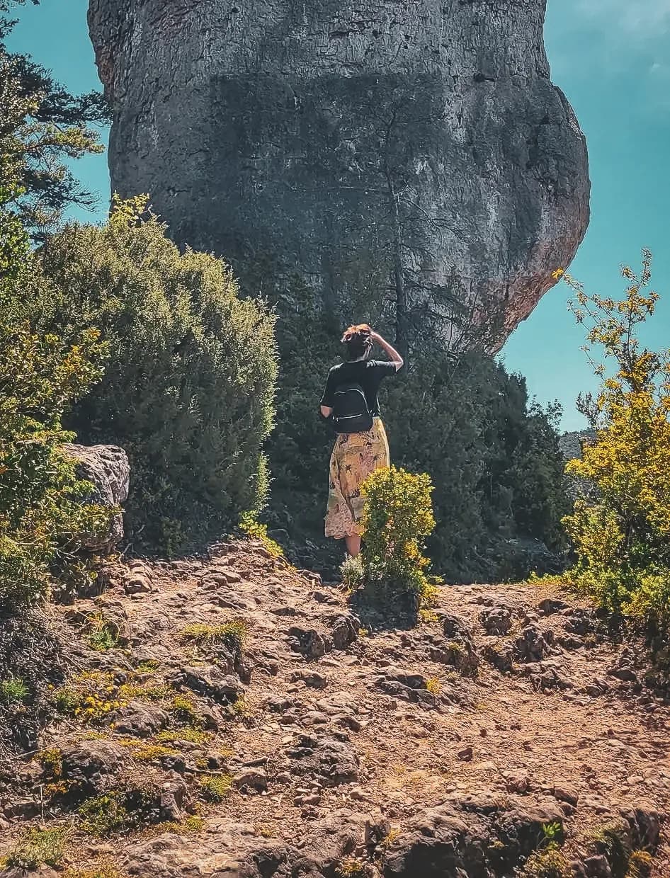 Une randonneuse contemplant une imposante formation rocheuse au cœur des Gorges du Tarn.