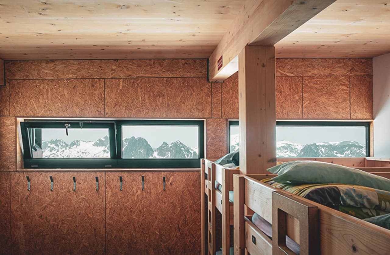 Warm, modern interieur van een hostel met adembenemend uitzicht op de besneeuwde toppen.