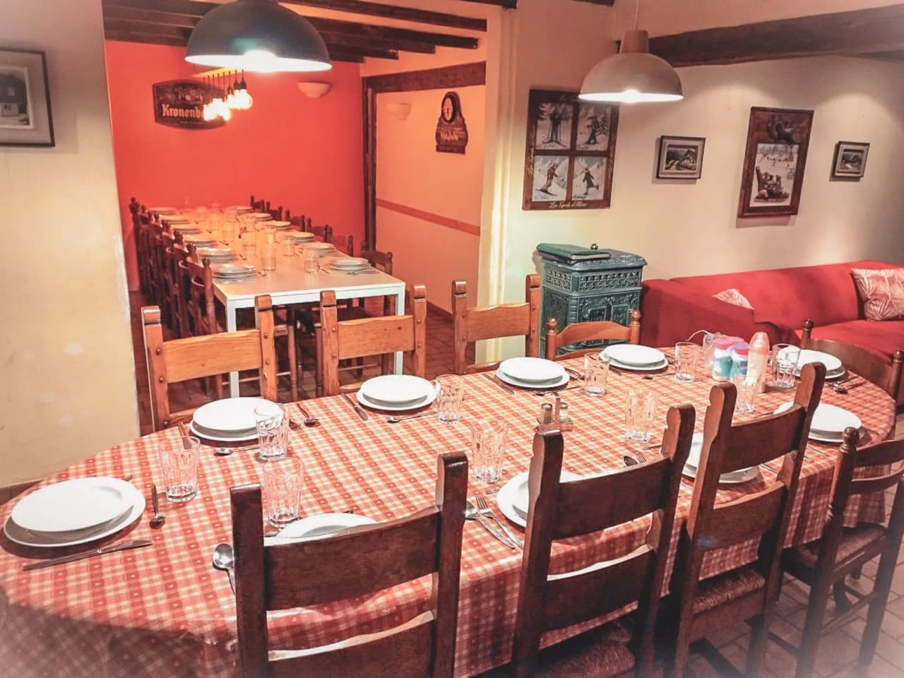 Gezellige eetzaal met grote tafel, geruit tafelkleed, houten stoelen en vriendelijke sfeer.