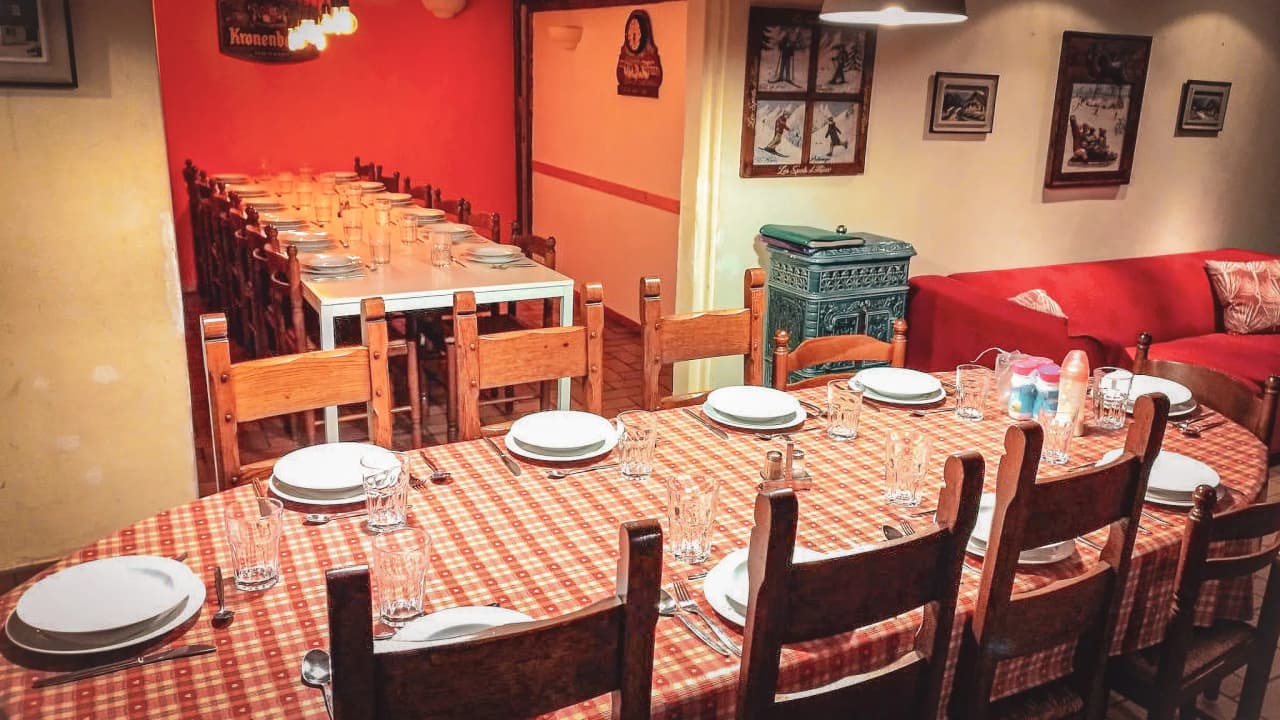 A convivial table set with elegant crockery in a warm atmosphere, ready to host a meal.