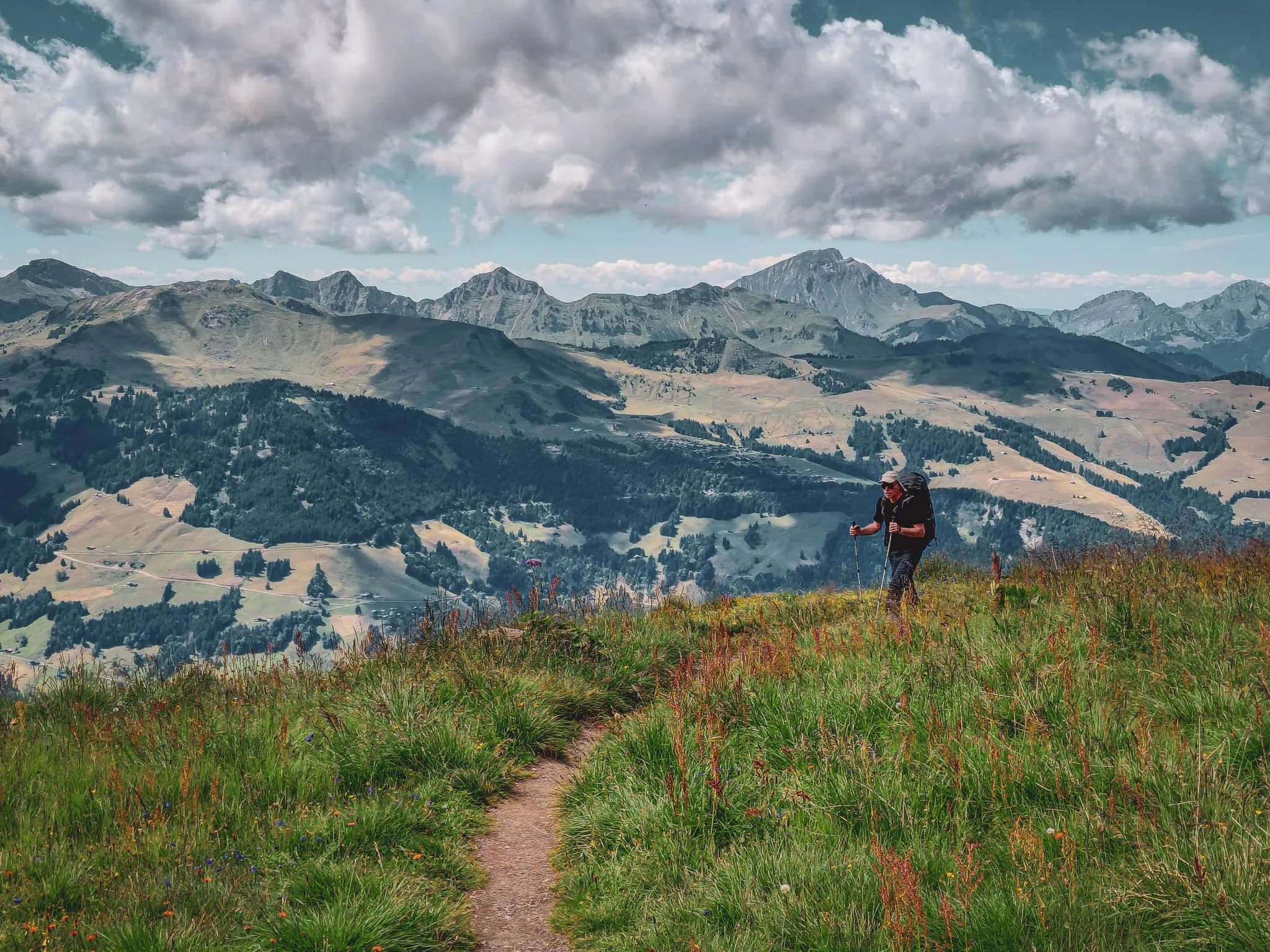 A captivating mountain landscape with a steep, textured summit dominating a gentle slope. Streaks of snow stretch across the ground, contrasting with the brown hues of the earth. The sky is d
