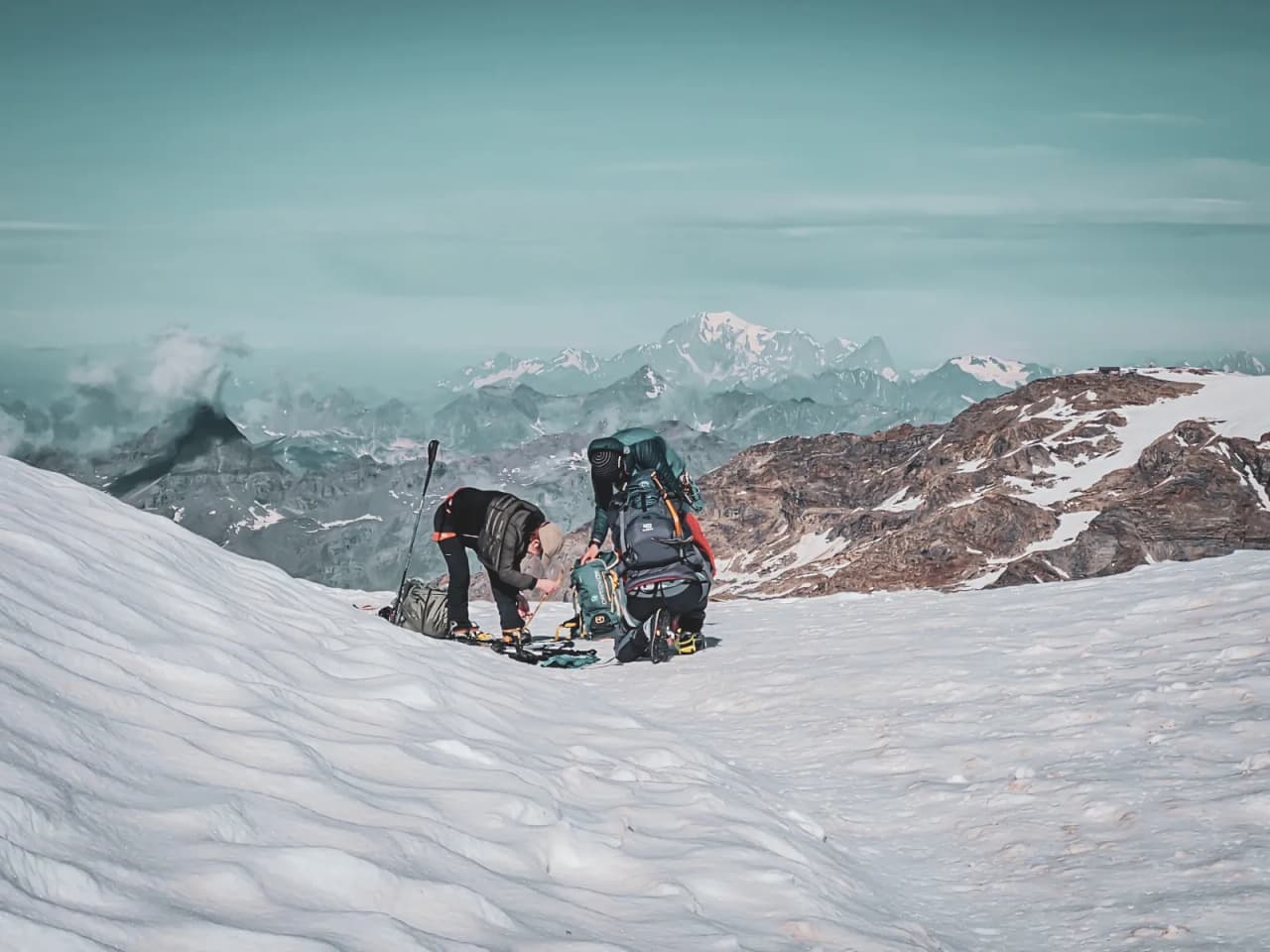 Mountaineers at the snow-covered summit, preparing for the ascent with breathtakingly spectacular views.