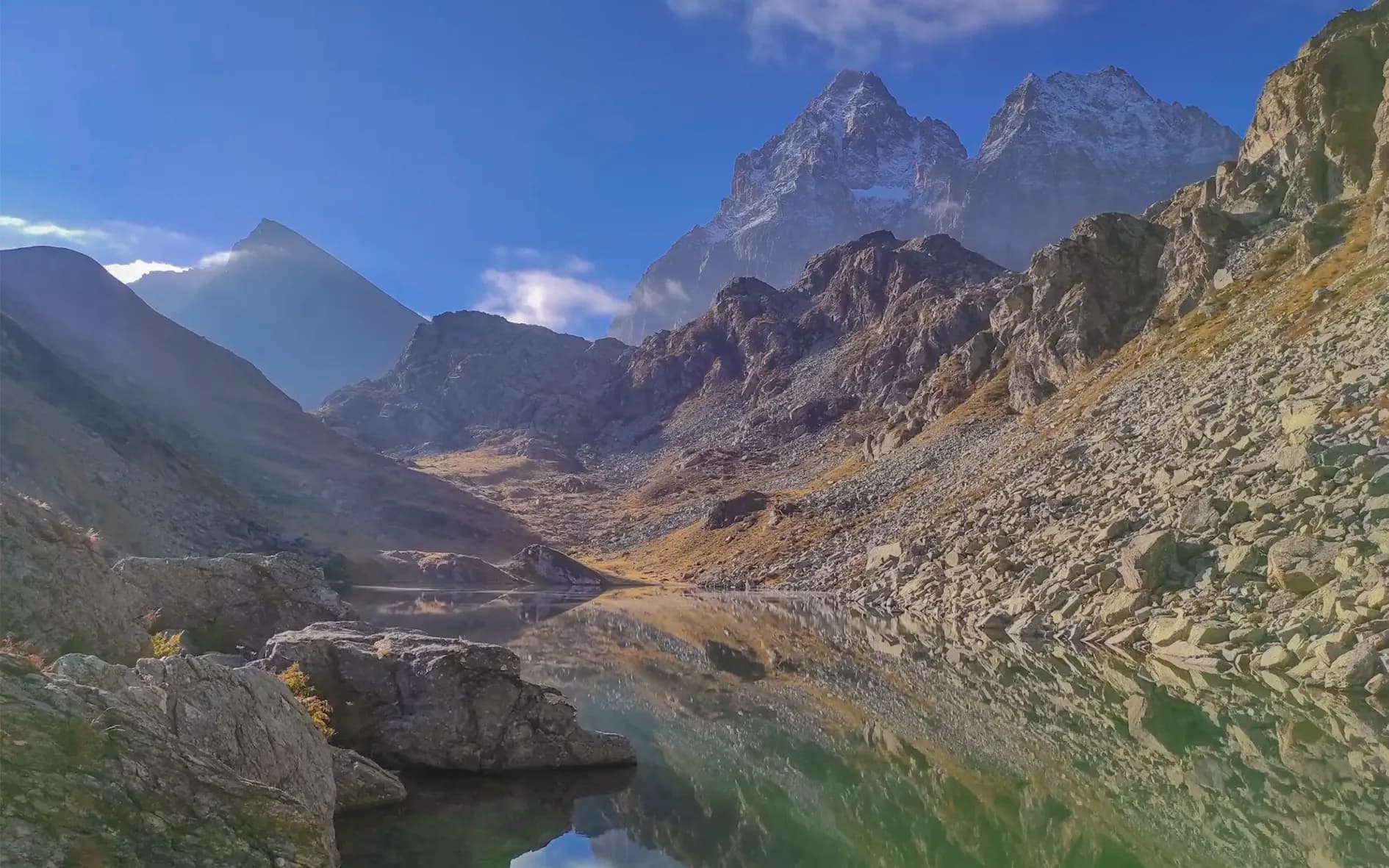 The majestic panorama of Mont Viso, reflecting on a peaceful lake, invites you to escape.