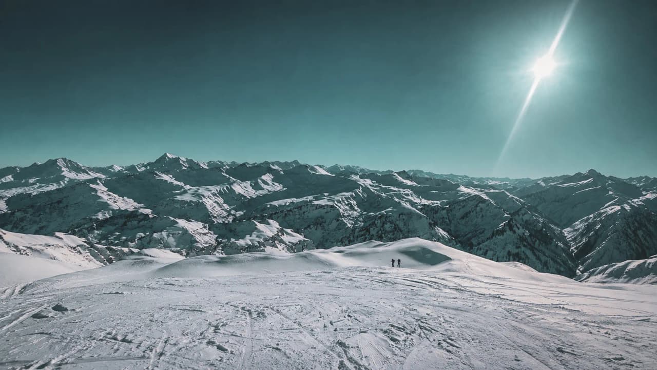 A breathtaking panoramic view of the snow-capped mountains, perfect for ski touring adventures.