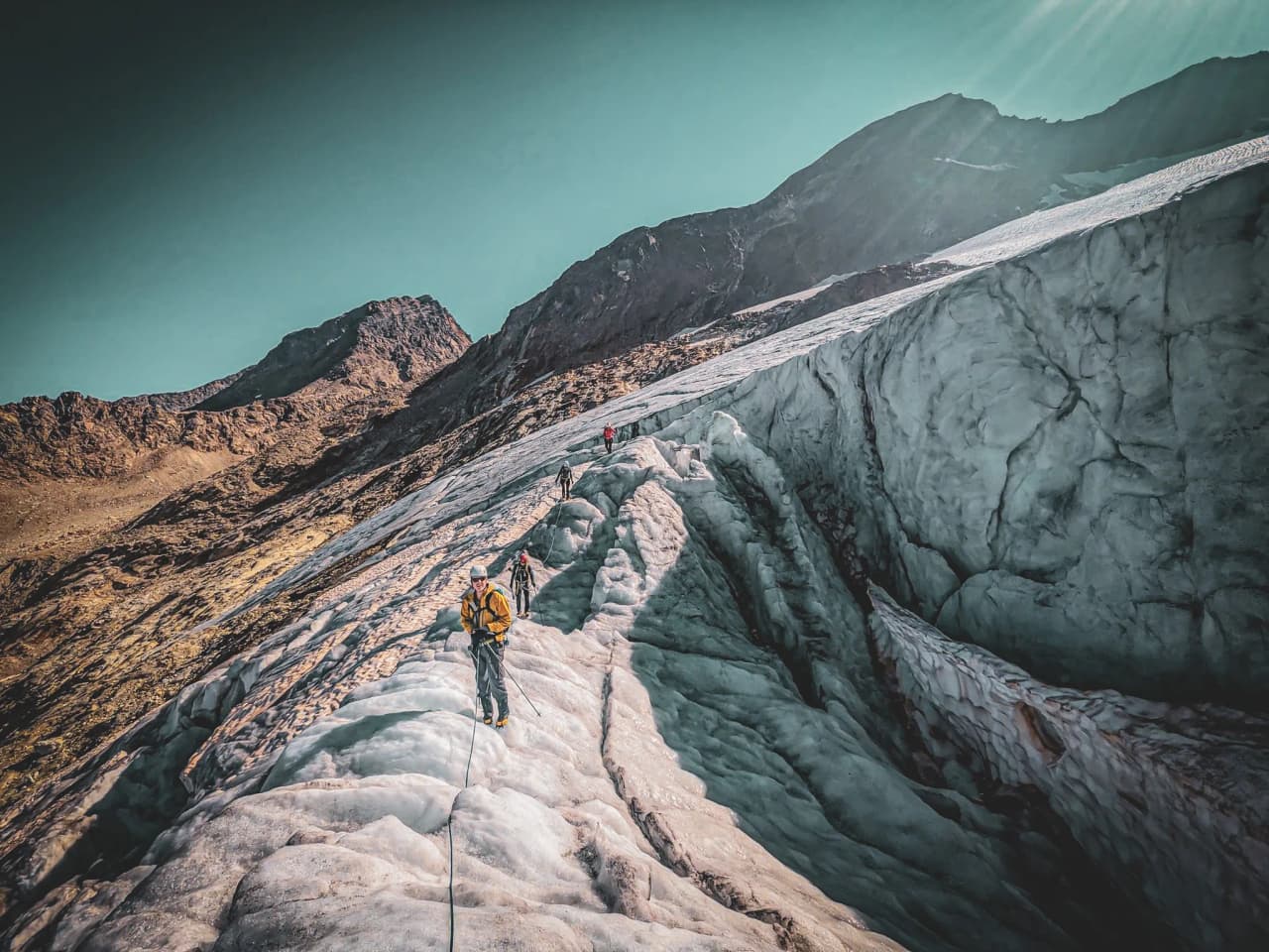 Grimpez sur le glacier, entouré de sommets majestueux, une aventure alpine inoubliable.