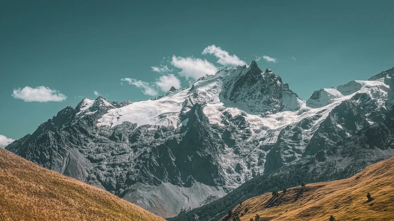 Majestueuses montagnes alpines sous un ciel azur, invitation à l'aventure en pleine nature.
