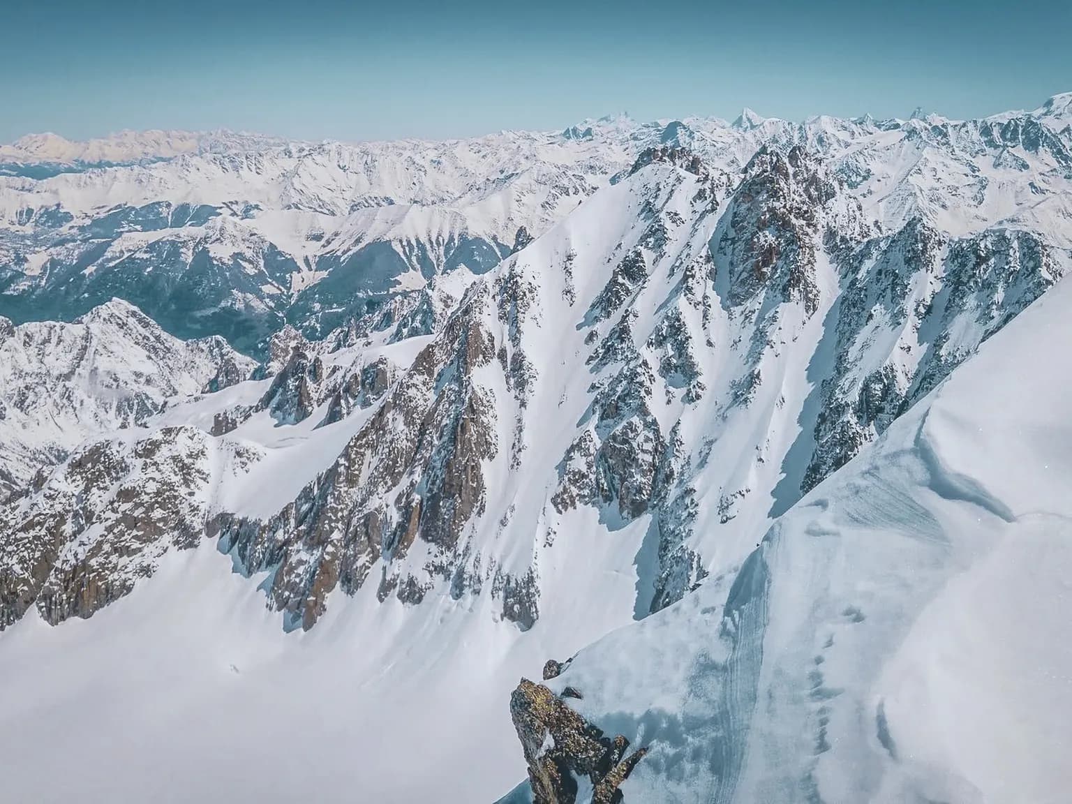 Spectaculaire panorama des glaciers du Mont Blanc, avec des sommets enneigés sous un ciel bleu éclatant.