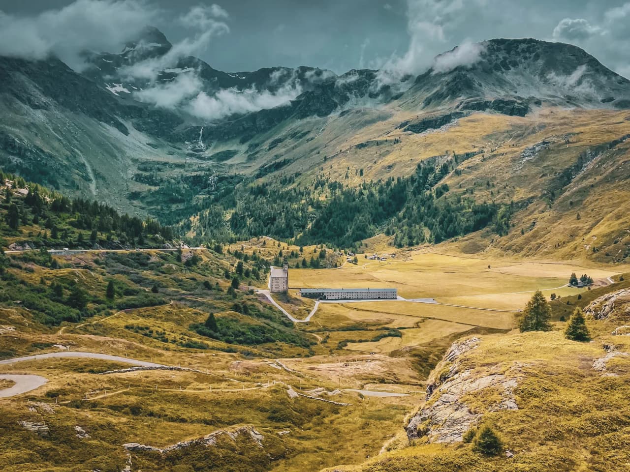 A vast green valley surrounded by majestic mountains, ideal for alpine exploration.