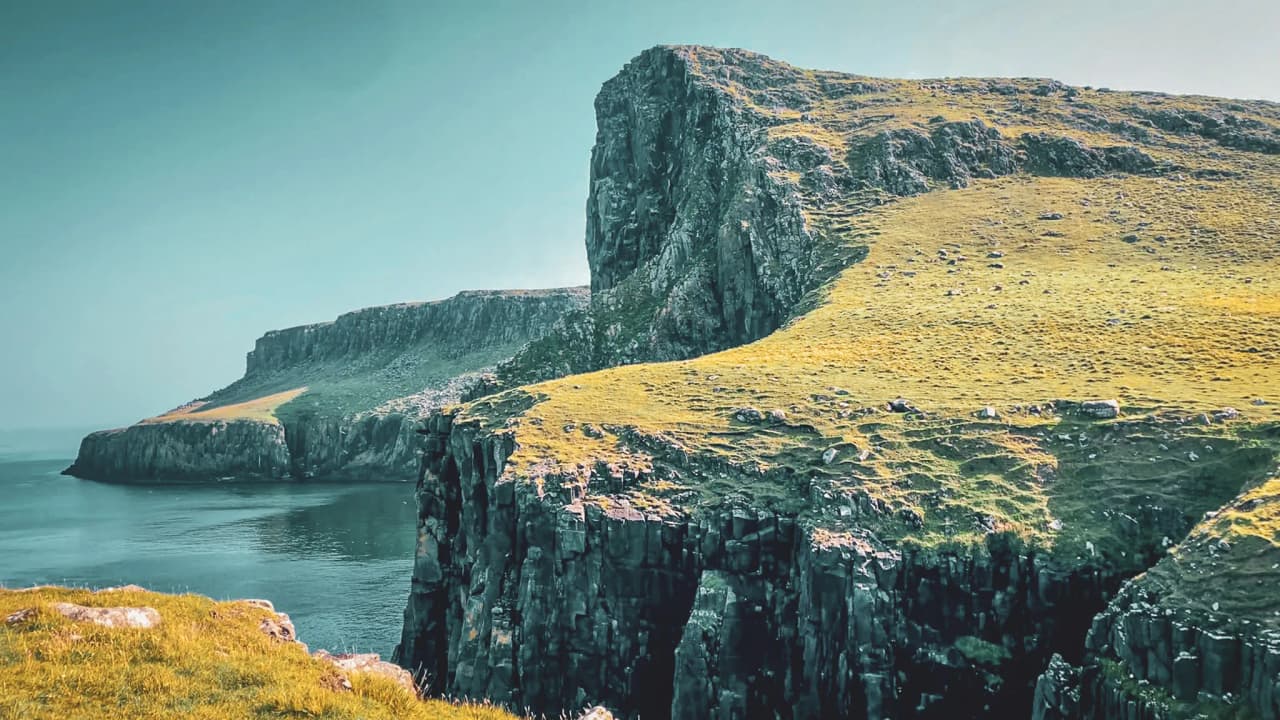 Duizelingwekkende kliffen torenen uit boven het rustige water, typisch voor het eiland Skye. Ideaal voor avontuur!