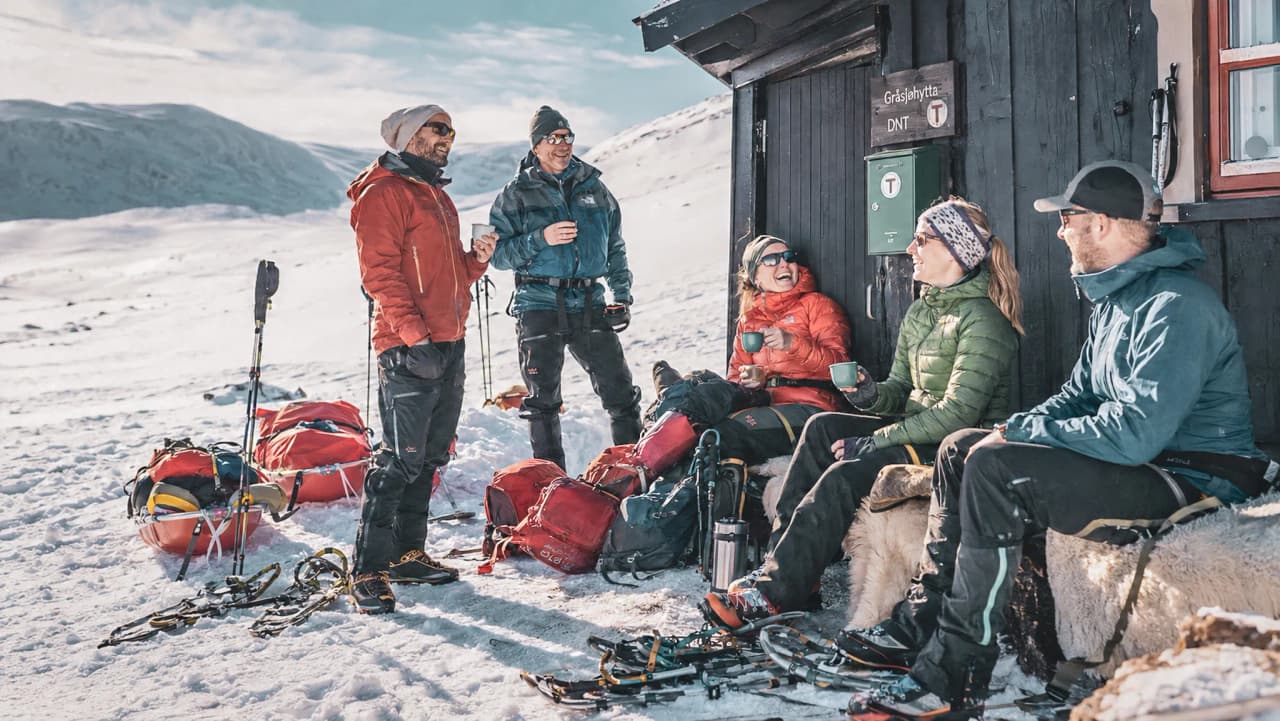 Een groep avonturiers in Lapland, die samen een gezellig moment beleven in de sneeuw, te midden van de majestueuze natuur.