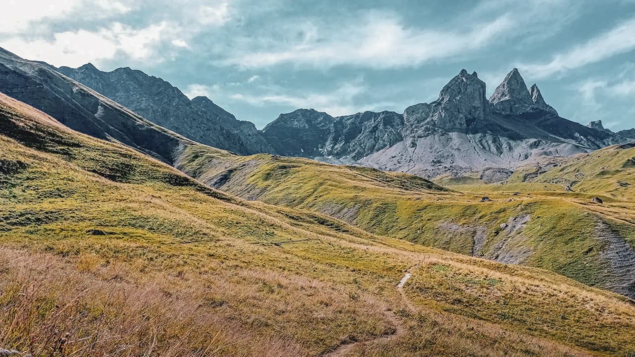 Paysage alpin spectaculaire avec des sommets majestueux sous un ciel bleu, invitant à l'aventure.
