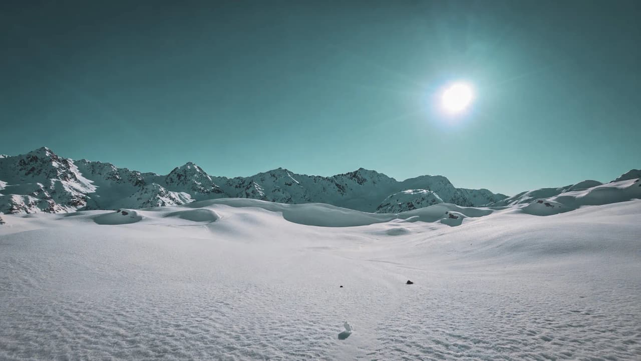 A snow-covered landscape in the Beaufortain, with majestic mountains beneath a brilliant blue sky – an invitation to adventure.