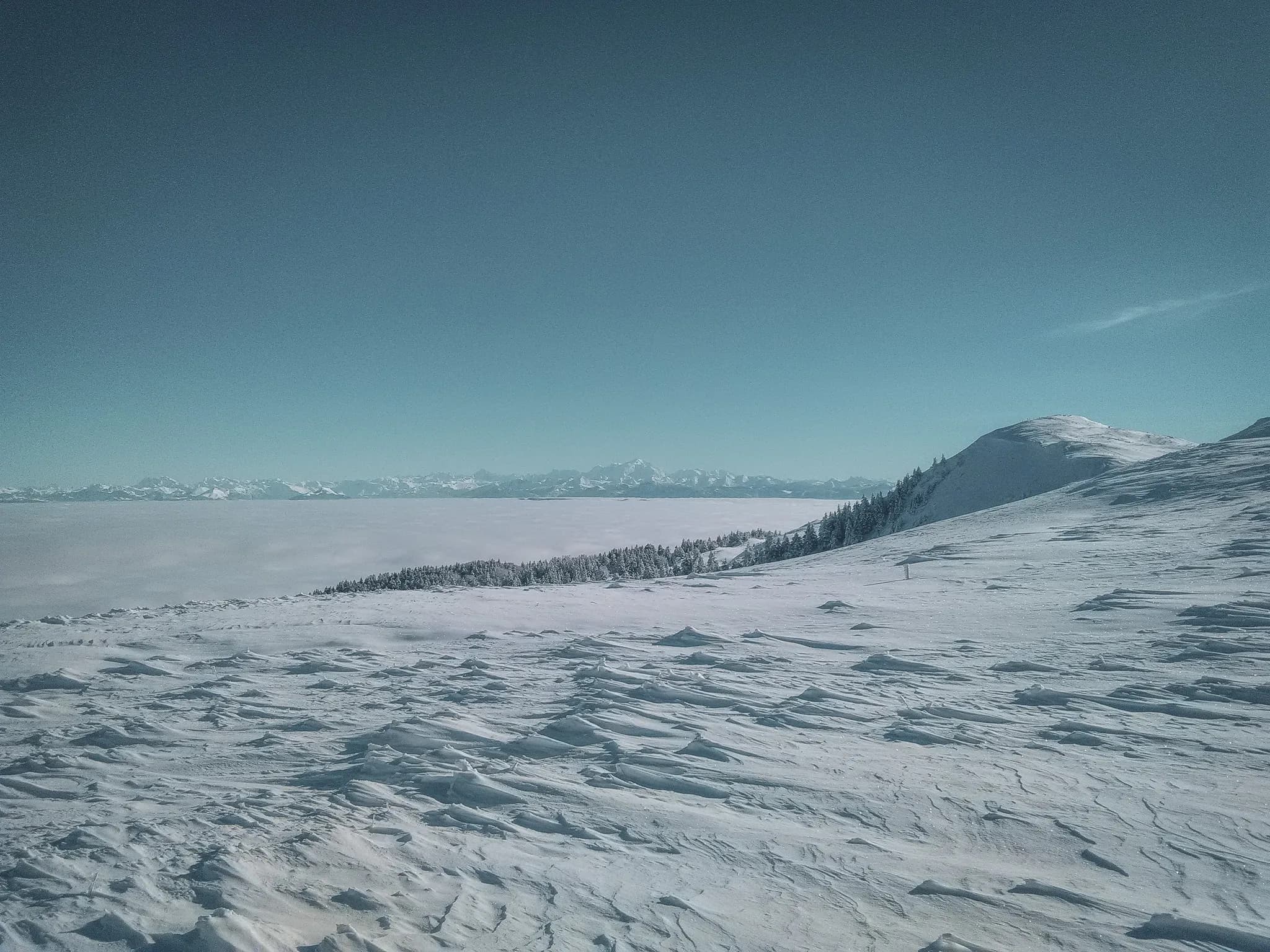 Immense besneeuwde panorama's van de Zwitserse Jura, onder een stralend blauwe hemel, een uitnodiging tot avontuur.
