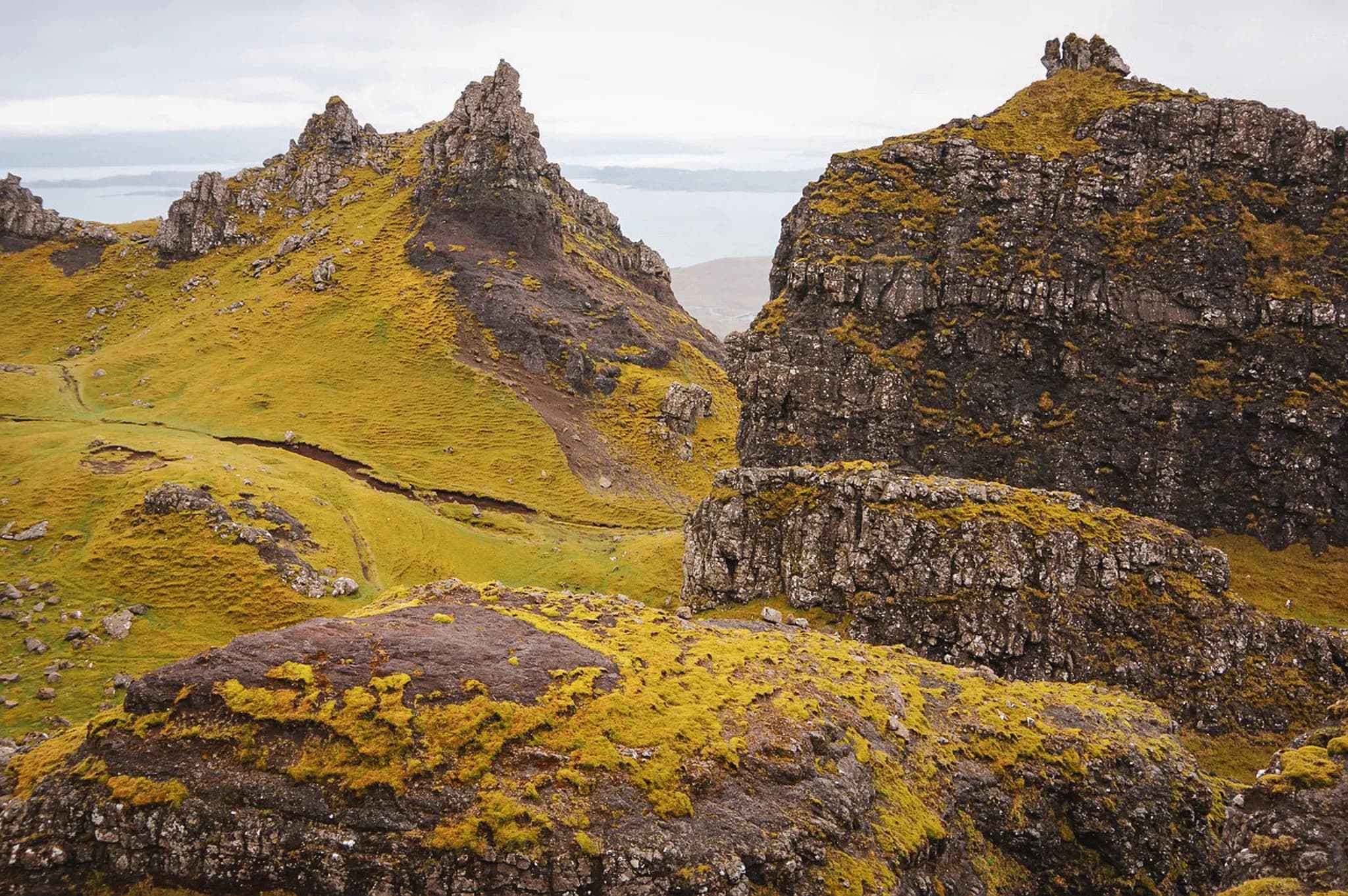 Hikers discovering the majestic landscapes of the Isle of Skye, between ridges and green valleys.