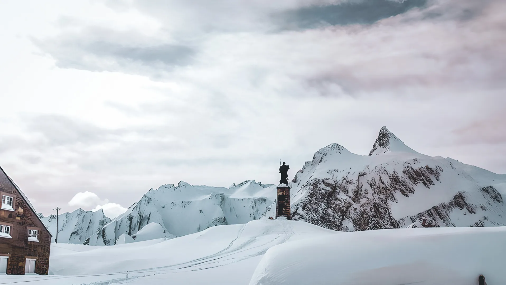 Een besneeuwd panorama over de Grote Sint-Bernardpas, met majestueuze bergen en een schilderachtig Berghut.
