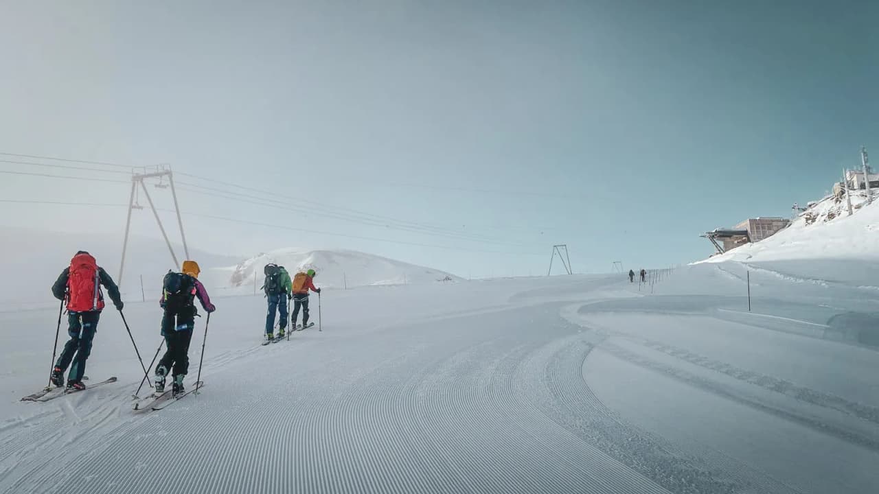 A group of skiers on a snowy, sunny expedition, surrounded by majestic mountains.