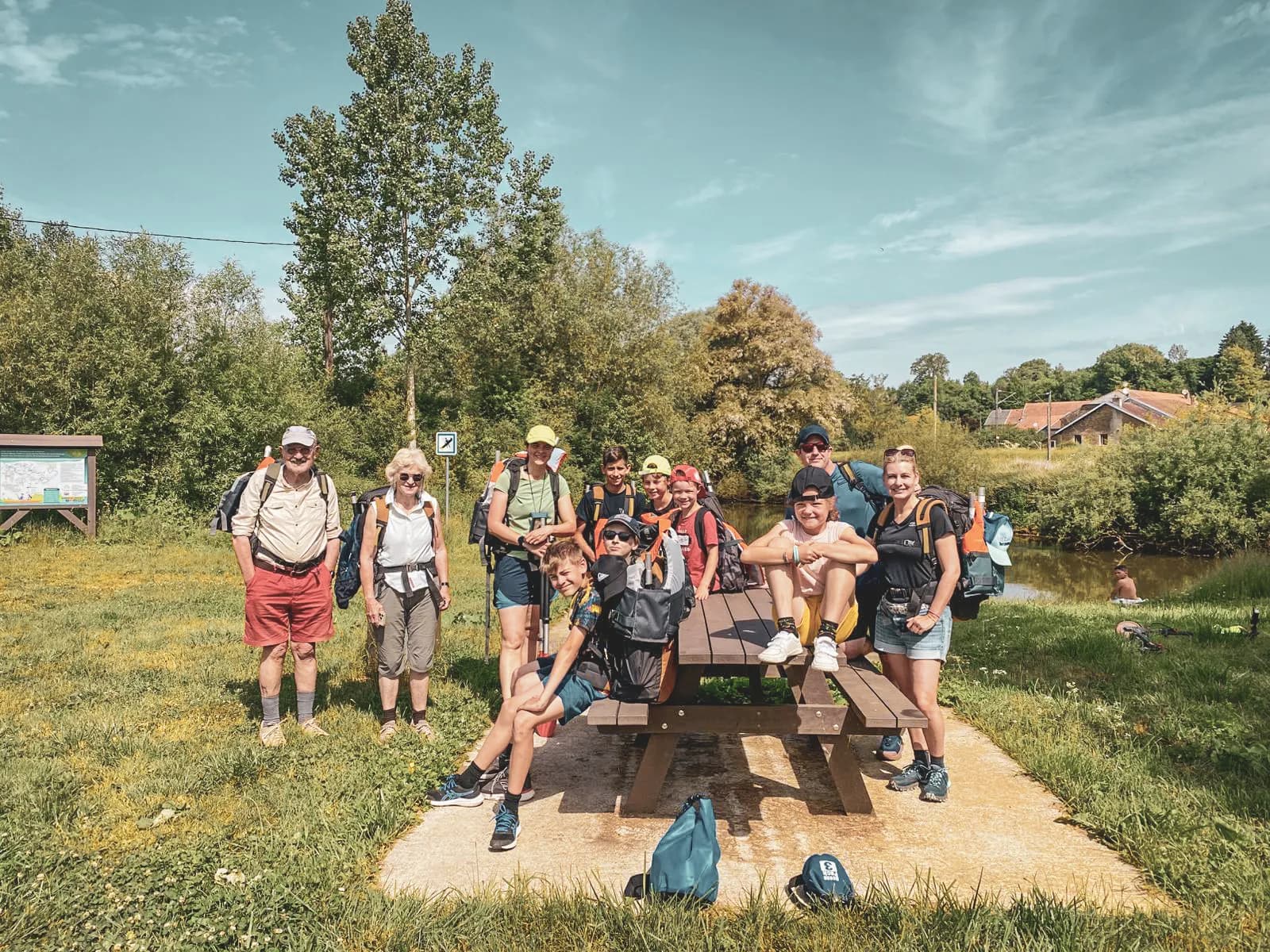 Een lachende groep aan de oevers van de Semois, klaar voor een packraftavontuur in het hart van de Ardennen.