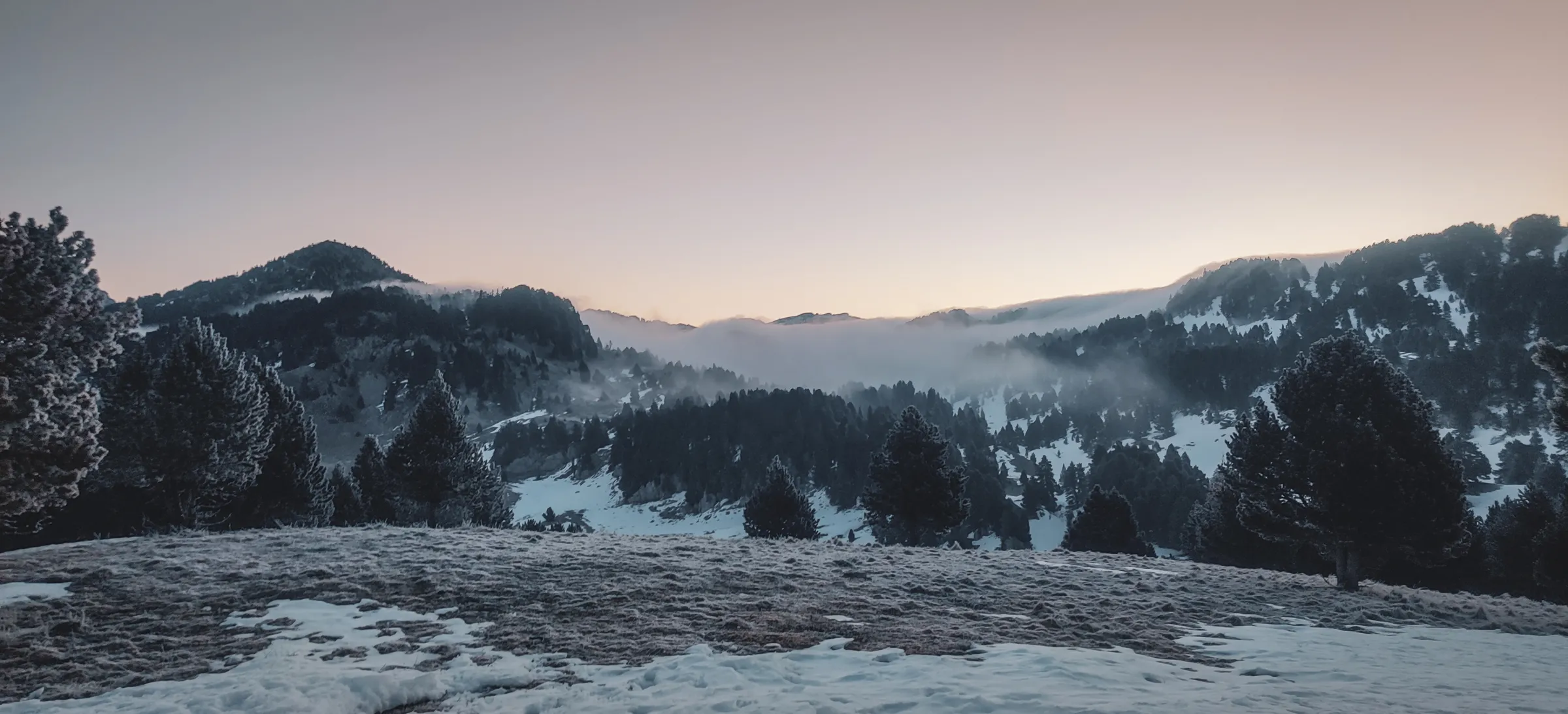 Het berglandschap van de Vercors bij zonsopgang, gehuld in mist en verse sneeuw, een uitnodiging tot avontuur.