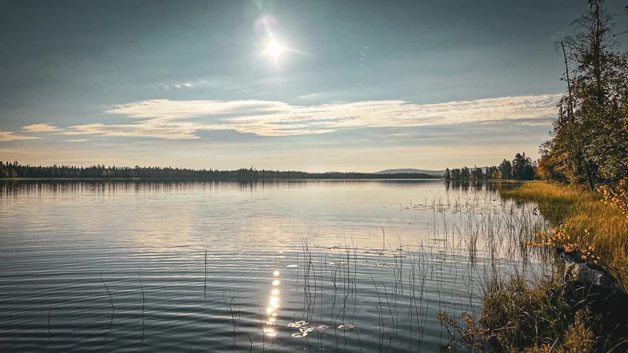 Een vredig meer onder een zonnige hemel, een weerspiegeling van de omringende boreale bossen. Ontsnapping gegarandeerd!