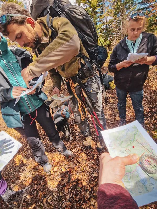 Groep in het wild, kaarten bestuderen tijdens een bushcraft-expeditie in de Vercors.