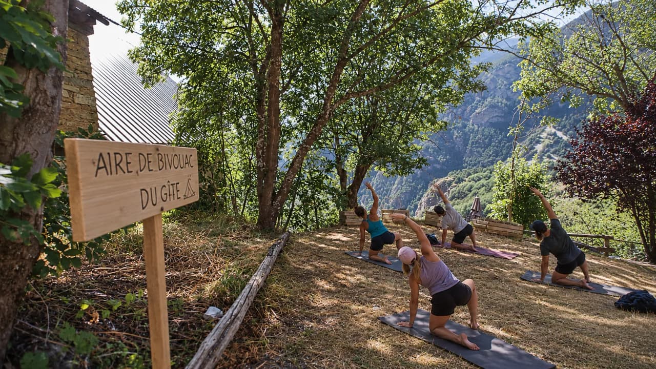 De deelnemers doen mee aan een yogasessie in de open lucht, omringd door groene bergen.