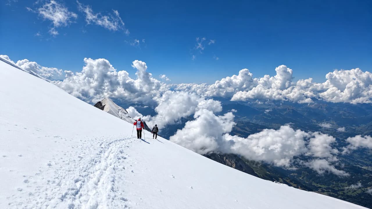 Randonneurs sur la neige, majestueux sommets et nuages, une aventure alpine à couper le souffle.