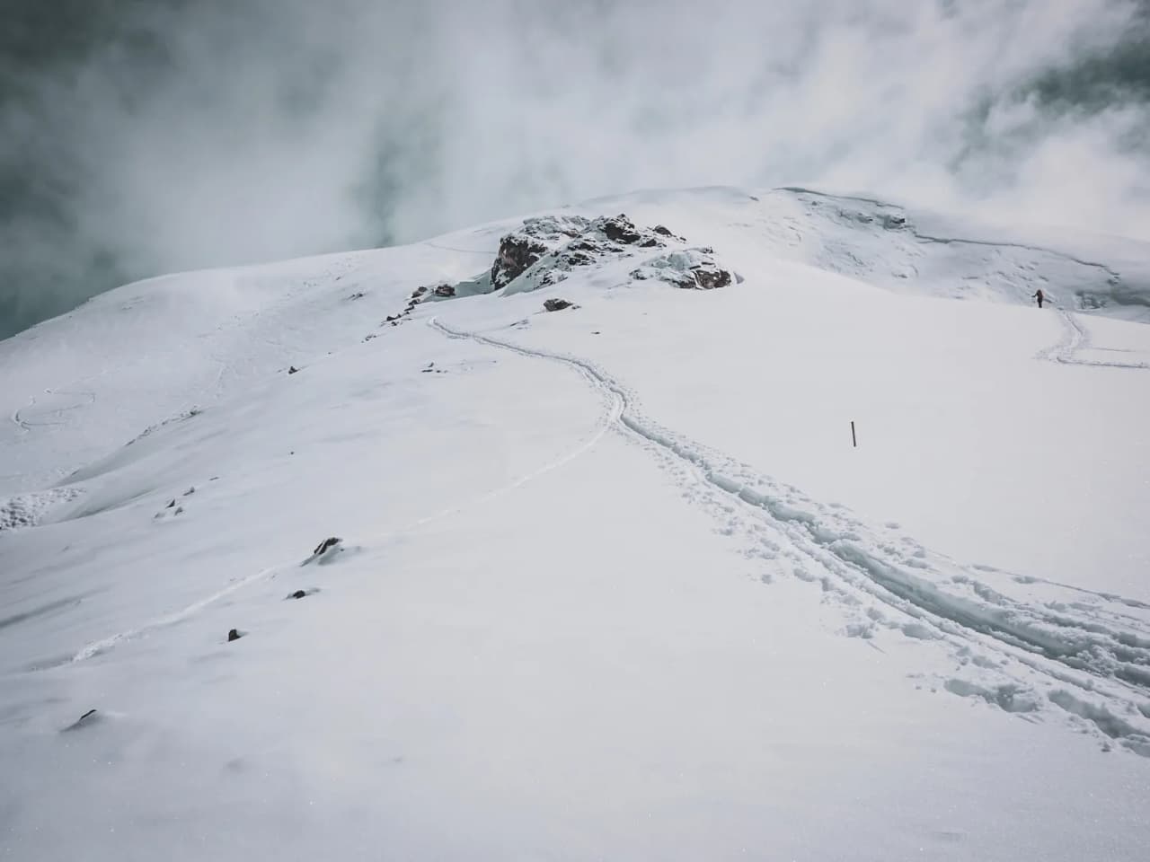 Des cimes enneigées sous un ciel nuageux, invite à l'aventure en ski de randonnée.