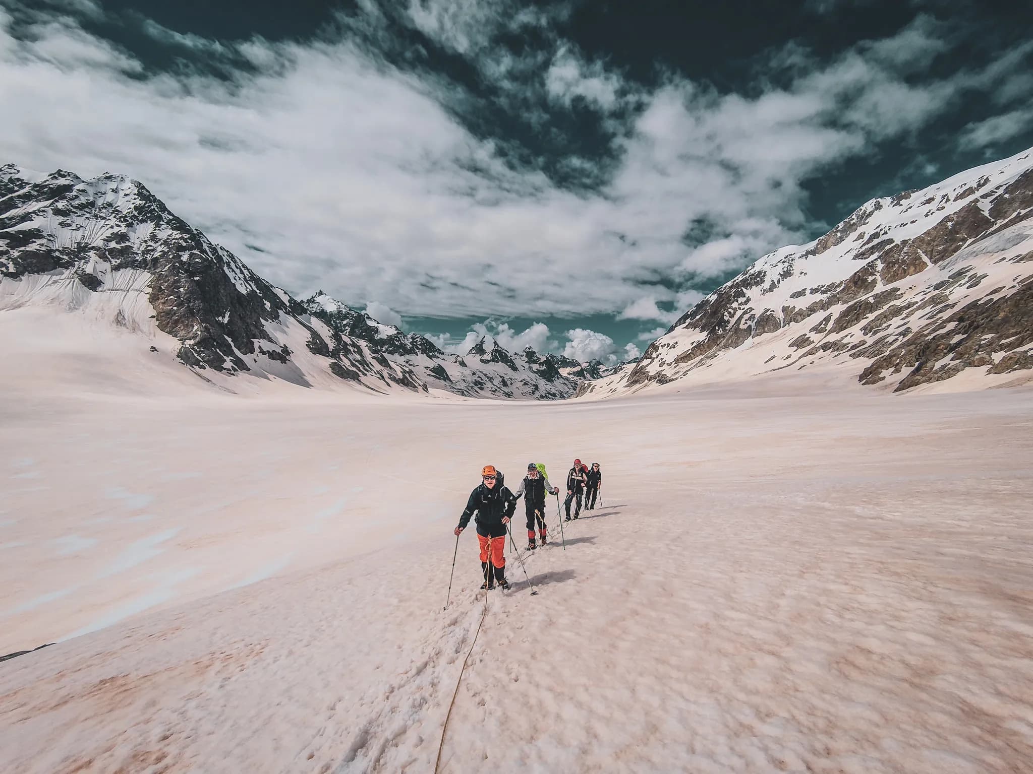 A group of climbers on a glacier, marvelling at the glittering Alpine peaks.