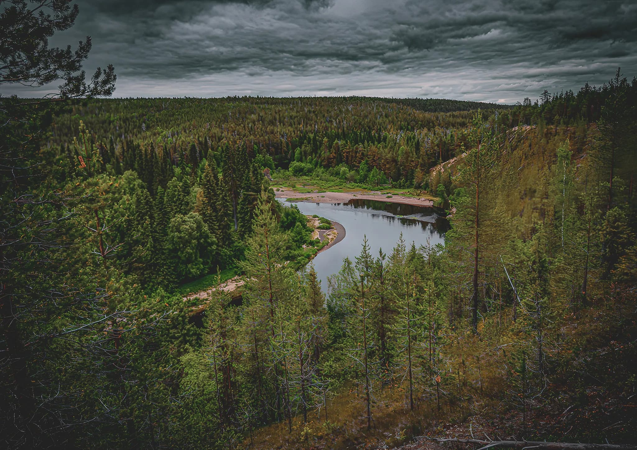 Magnificent views of the Oulanka rivers, surrounded by lush green forests under dramatic skies.
