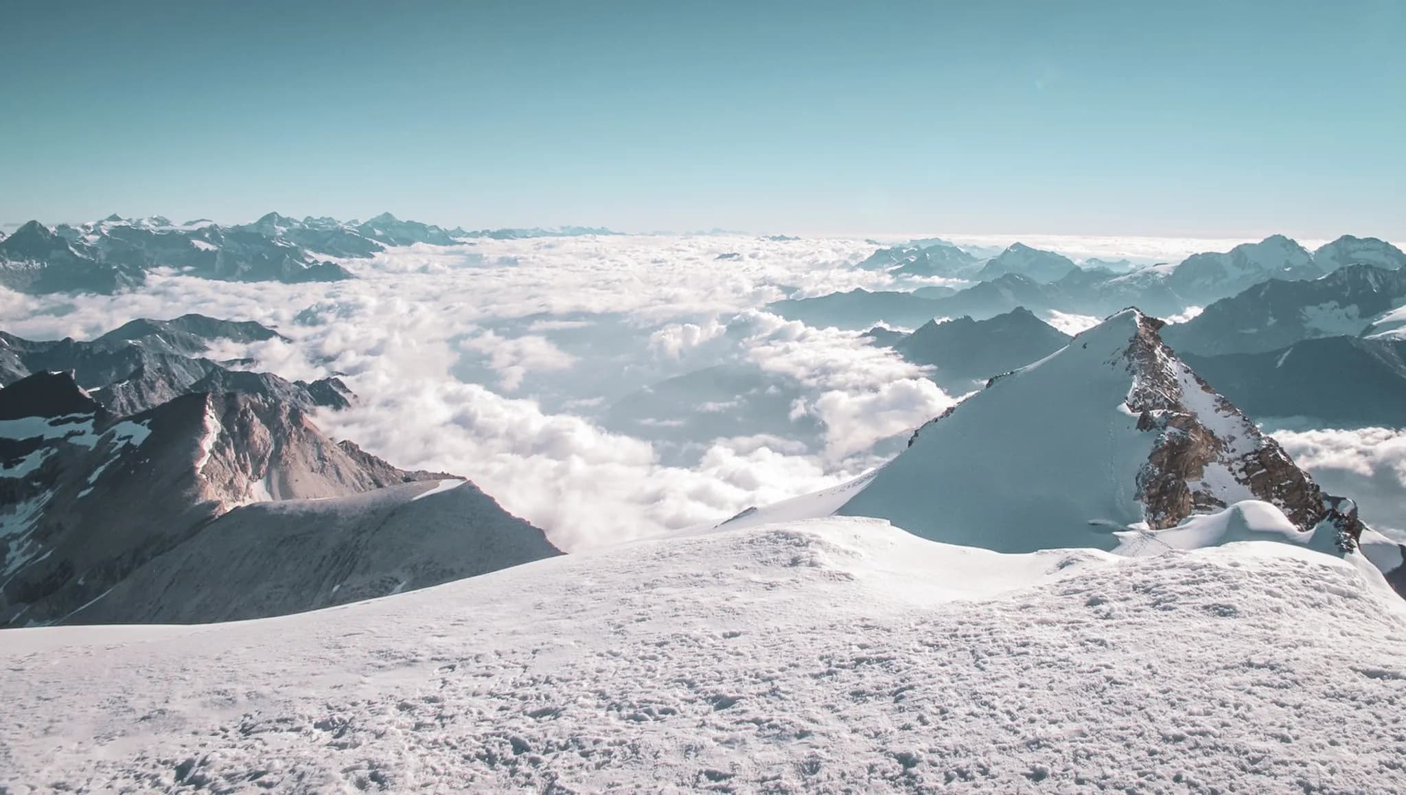 Breathtaking panoramic views of the Alps, snow-capped peaks rising above the clouds.