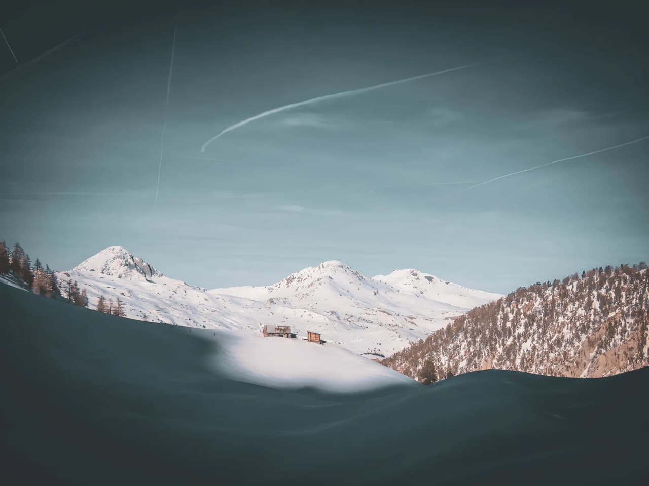 Breathtaking snow-covered landscapes between mountains and cosy chalets, an invitation to travel.