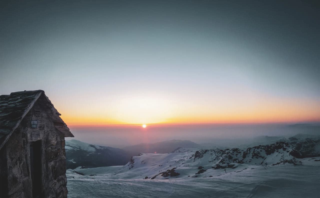 Coucher de soleil sur les montagnes enneigées, paisible et enchanteur.