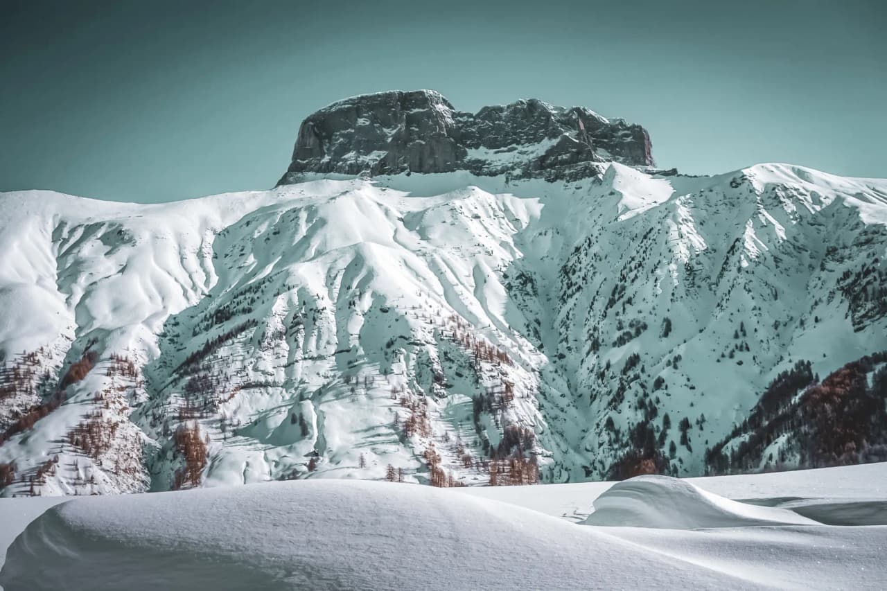 Montagnes enneigées sous un ciel turquoise, invitation à l'aventure au lac de Serre-Ponçon.