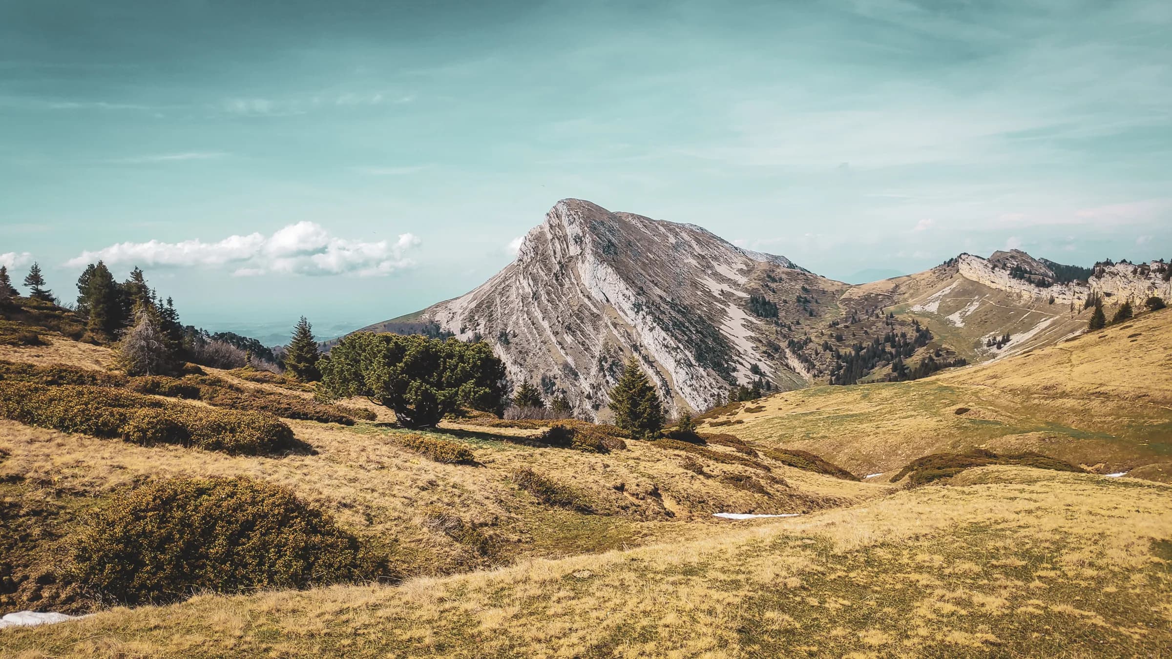 Montagne majestueuse sous un ciel azur, cadre idéal pour une randonnée en pleine nature.