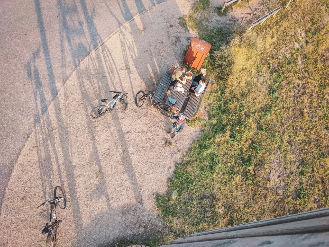 cyclists around a table seen from above on a Dutch beach