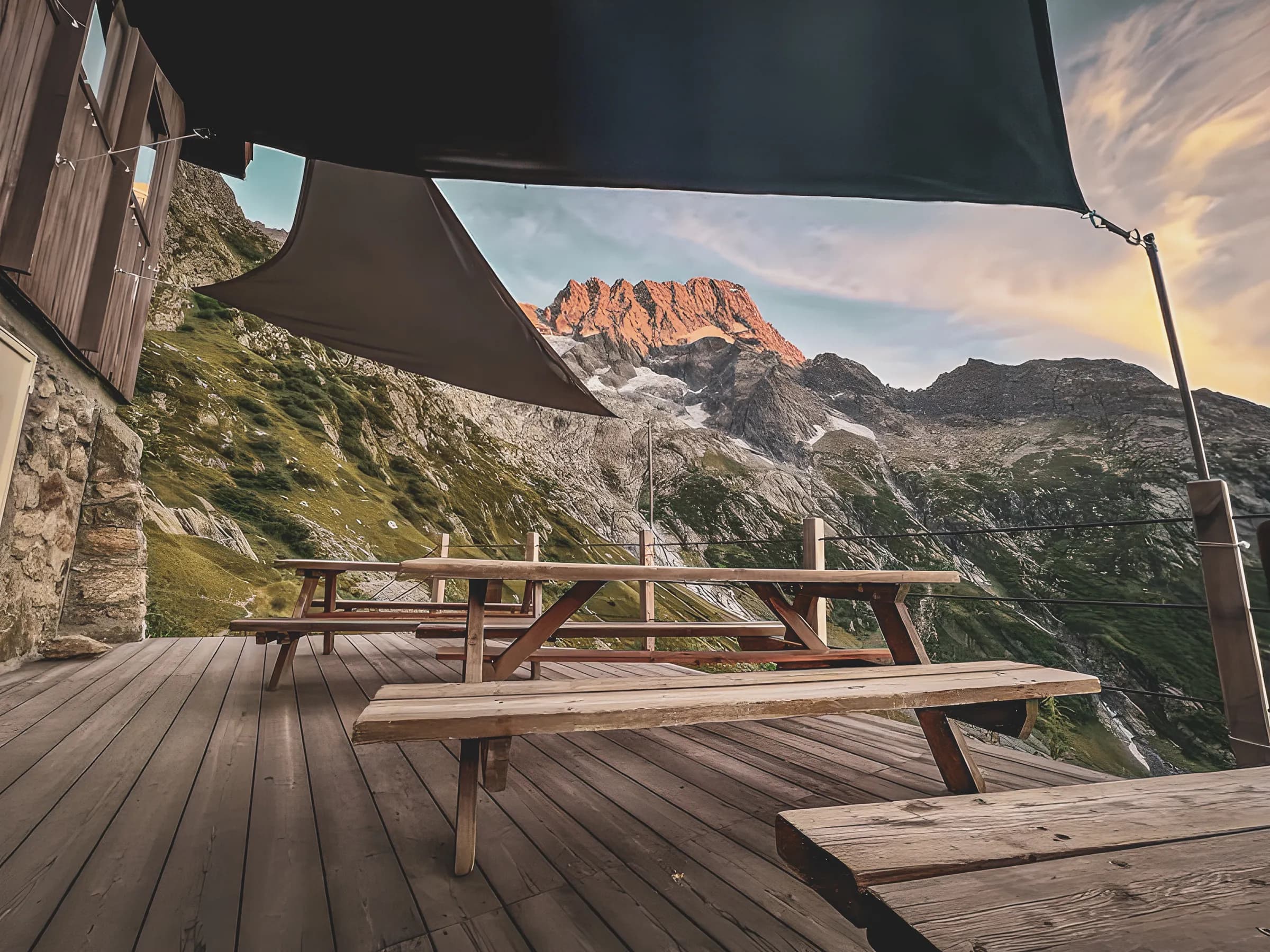 Terrasse en bois face aux montagnes des Écrins, ambiance paisible et nature sauvage.