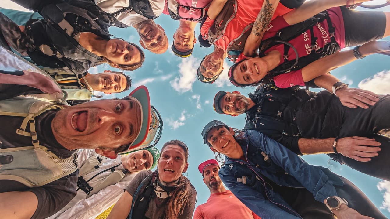 A smiling group of athletes around a sunny view, ready for adventure in the Auvergne.