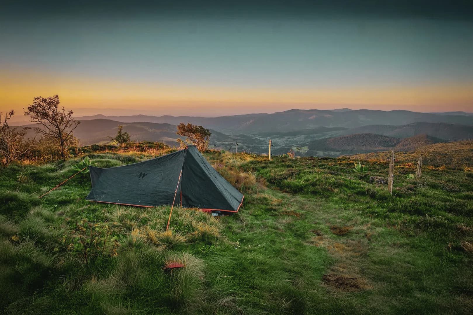A black tent at sunset, overlooking the green valleys of the Vosges. A natural escape.